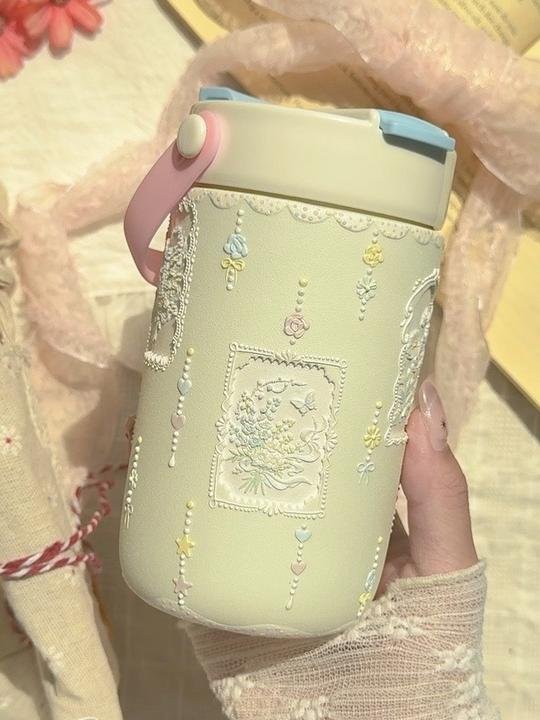 Hand-painted cream ceramic travel cup with floral relief details
