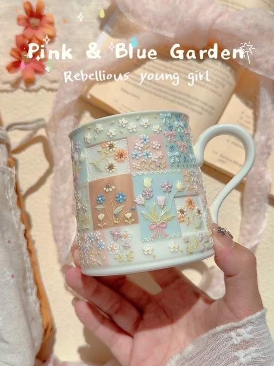 Hand-painted pastel blue ceramic mug with raised floral details