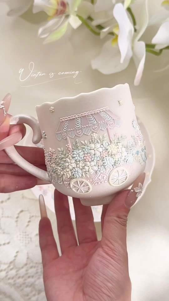 Handmade white ceramic mug with raised flower cart decoration