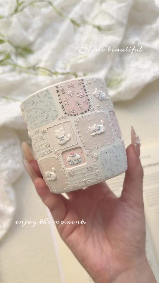 Handmade pastel ceramic cup with raised cat and cake decorations