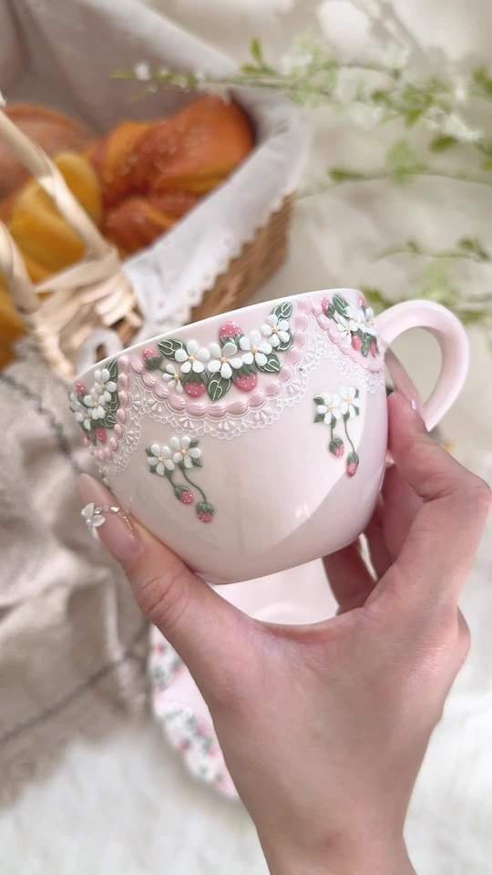 Handmade pink ceramic teacup with strawberries and raised flowers