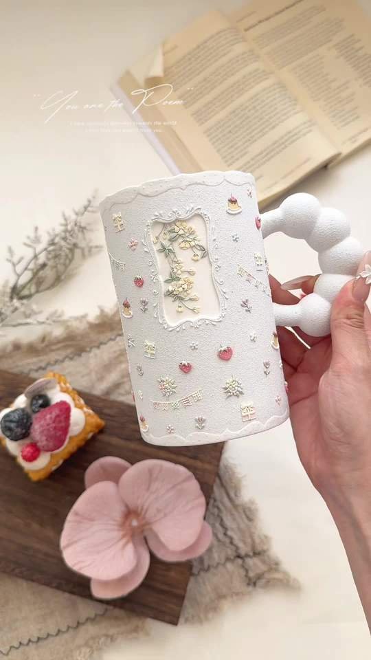 Handmade white ceramic mug with bubble handle and raised floral details